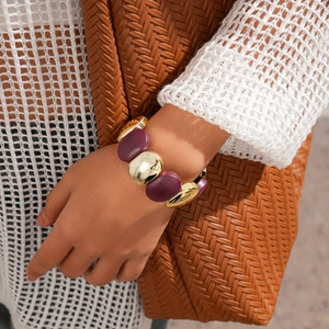 Gros plan d'un large bracelet en acrylique avec résine violette et maillons dorés