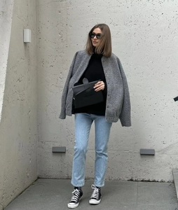 Street style view of a loose grey wool jacket paired with light blue textured denim jeans