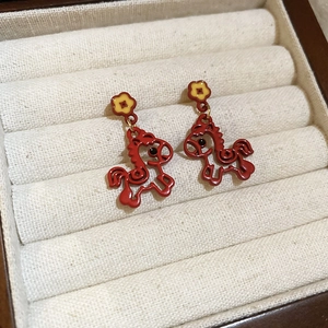 Détail des boucles d'oreilles cheval plaquées or 18K avec émail rouge et fleur