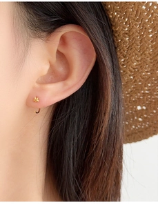 Detailed close-up showing the elegant fit of the star-shaped gold earrings on ear