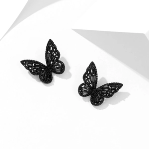 Detailed close-up of butterfly stud earrings in black finish with inlaid dark stones