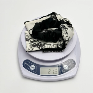 Detailed view of elegant black and white print satin scrunchie weighing 21.3 grams
