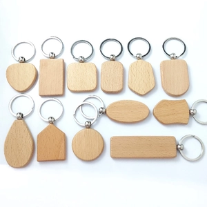 Flat lay macro view of multiple shaped blank beech wood keychains with metal rings