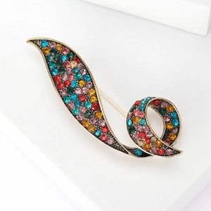 Macro shot of vintage gun-black brooch with multi-color rhinestones in a sleek flow design