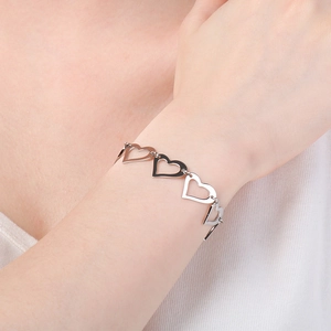 Close-up of minimalist silver heart-shaped hollow link bracelet on a woman's wrist