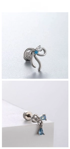 Detail of bow-shaped stud earrings with blue teardrop pendants and cubic zirconia