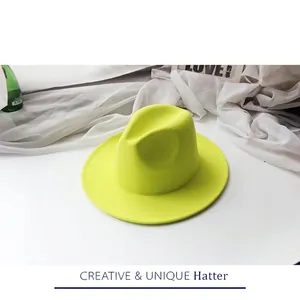 Flat lay view of a neon yellow wool fedora hat with wide brim on white background