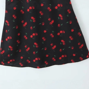 Robe dos nu style français avec imprimé cerises sur texture de tissu noir