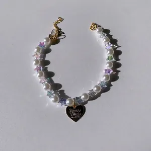 Elegant pet collar with white faux pearls, iridescent stars, and a gold heart pendant
