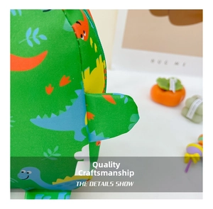 Close-up of the fine stitching and 3D fin details on the green cartoon dinosaur kids backpack
