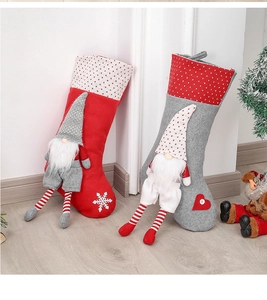 Detail of red and grey Christmas stockings with 3D long-legged gnome dolls on wood floor
