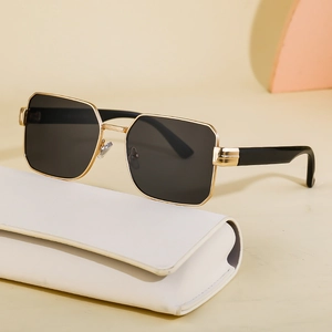 Square metal frame sunglasses with gold temples and black lenses on white case