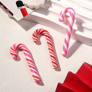 Detailed view of red and pink striped clay candy canes for DIY holiday hair accessories