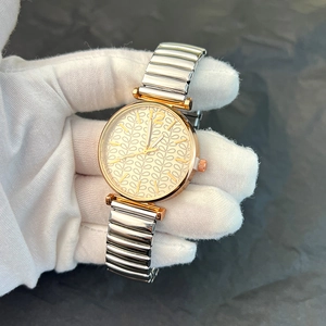 Detail of rose gold ladies watch with textured dial and bicolor flexible elastic band