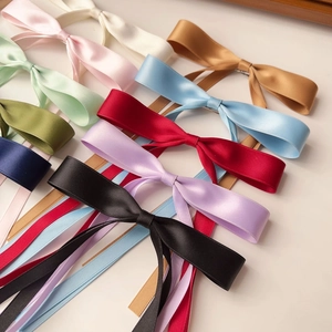 Flat lay of colorful satin bow hair clips with long streamers in multiple pastel colors