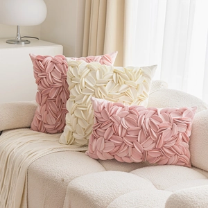 Detailed view of pink and beige floral textured pillows on a cozy sofa setting