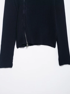 Detail of navy ribbed knit cardigan featuring an asymmetrical silver metal zipper
