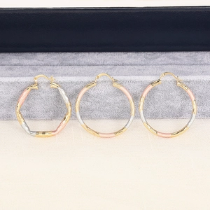 Detail view of tri-color geometric hoop earrings in gold silver and rose gold finishes