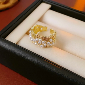 Dettaglio dell'anello placcato in oro con perle bianche e zirconi in una scatola nera