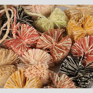 Close-up of handmade raffia tassels in bohemian earth tones showing detailed fiber texture