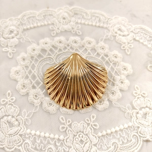 Macro shot of a golden starfish hair accessory with a polished finish on white lace