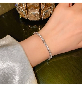 Close-up of sparkling silver tennis bracelet with round-cut zircons on a woman's wrist