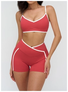 Detail of red two-piece yoga set with white trim, highlighting the V-neck top and high-waist shorts