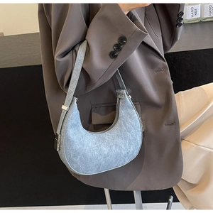 Detail of light blue crescent underarm bag showing snowy leather texture and silver buckle