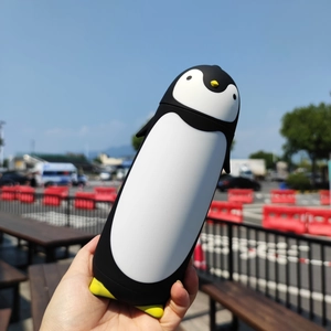 Outdoor close-up of a creative penguin-shaped stainless steel insulated water bottle