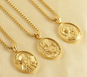 Macro view of 3D embossed St. Benedict and religious pendants in 18k gold-plated steel