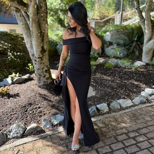 Détail d'une robe de soirée noire bustier avec une fente haute et un ourlet long au sol