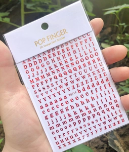 Macro detail of red 3D English letter nail art stickers model WG719 on packaging