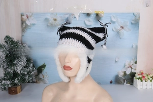 Detail of hand-knitted cat ear hat with black and white stripes and faux fur lining