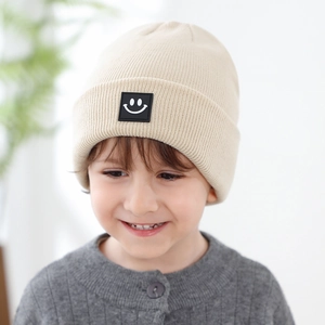 Berretto in maglia beige per neonati con toppa a faccina nera per calore autunno inverno