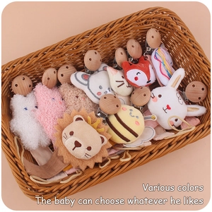 Basket of assorted beech wood pacifier clips with plush animal heads and linen straps