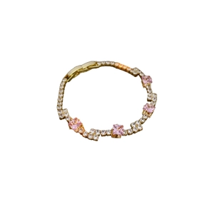 Elegant gold bracelet with pink square stones and white zircons on a white background