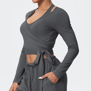 Detail of grey wrap yoga top with side tie design and slim fit athletic long sleeves
