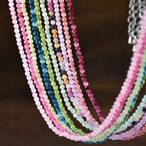 Detail of colorful natural semi-precious stone beaded necklace with metal extension chain