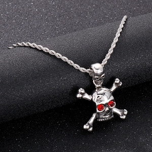 Close-up of hip-hop skull pendant with red rhinestone eyes and silver twisted chain