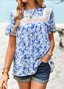 Detail of blue and white floral print top with lace splice and ruffle sleeves on beach