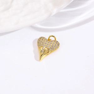Macro view of gold-plated heart pendant with shimmering rhinestones on white background