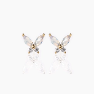 Macro detail of butterfly stud earrings featuring marquise-cut crystals and 18K gold base