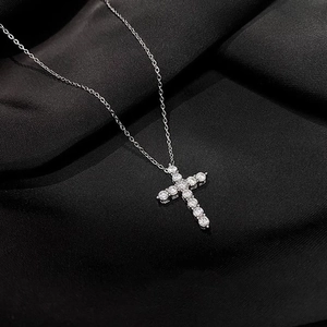 Silver stainless steel cross necklace with sparkling zircon on black silk background