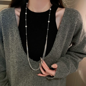Detail of silver long layered pearl necklace with elegant tassel fringe on a model