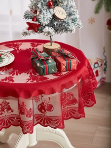 Detailed close-up of red Christmas lace tablecloth with bell, snowflake and deer patterns