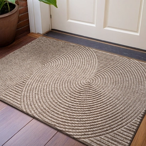 Detail of light brown doormat with swirl texture on wooden floor by a white door
