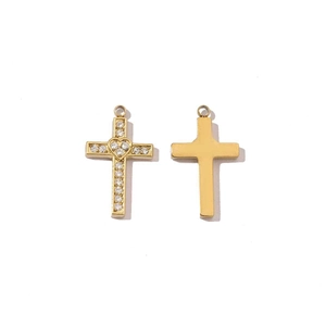 Detailed macro view of two gold stainless steel cross pendants with crystal and heart inlay