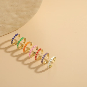 Set of seven colorful enamel heart rings in gold finish with an adjustable open design