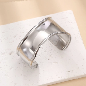 Detailed view of wide open silver titanium steel cuff bracelet with rolled edges on stone