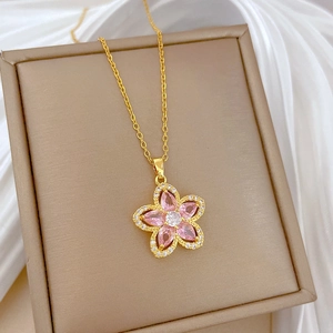 Close-up of pink flower pendant with crystals on gold titanium steel necklace chain